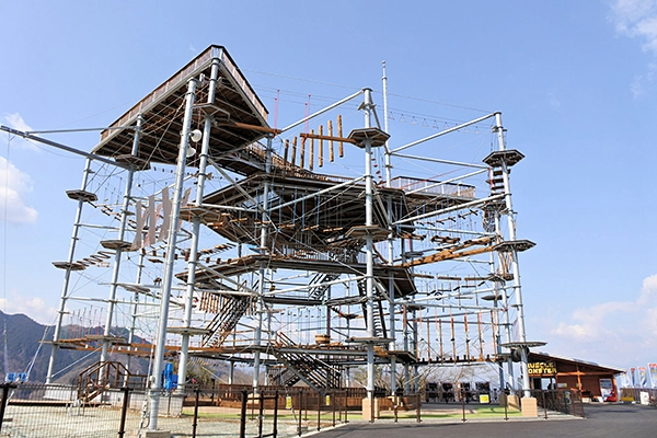 さがみ湖リゾートプレジャーフォレストのマッスルモンスター全景。山頂に建つ巨大アスレチック施設の様子
